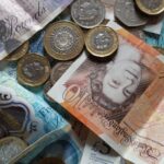 Close-up collection of British Pound notes and coins, showcasing UK currency.