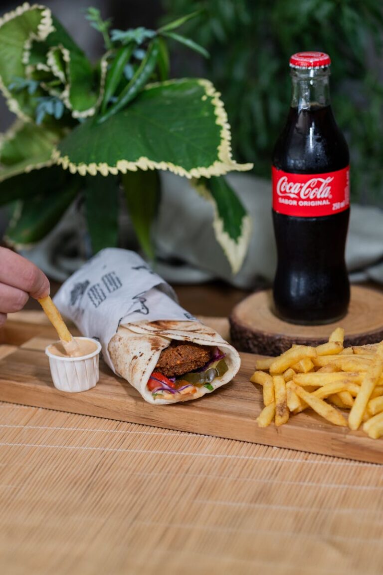 Falafel wrap, fries, and a refreshing drink create a perfect meal setting.